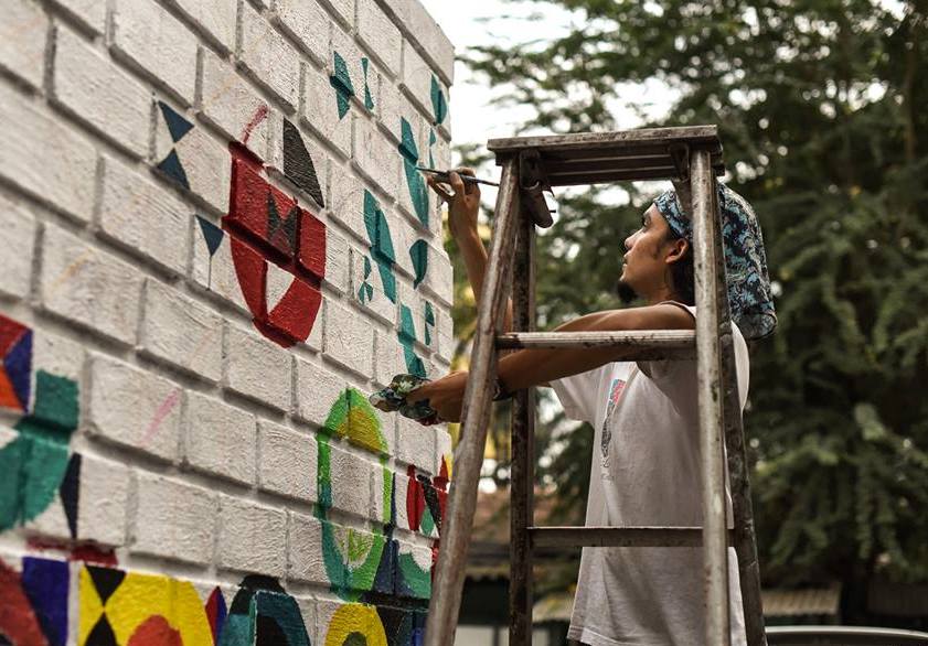 Artist Keith Pinto painting a mural